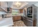 Modern kitchen with stainless steel appliances, wood cabinets, and a decorative light fixture at 3968 Orchard Hill Cir, Palm Harbor, FL 34684