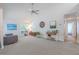 Comfortable living room with ample natural light, ceiling fan, and plush carpeting at 3968 Orchard Hill Cir, Palm Harbor, FL 34684
