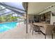 Outdoor patio features a table with seating and a view of the screened-in pool at 3968 Orchard Hill Cir, Palm Harbor, FL 34684