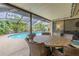 Covered patio with dining table overlooking screened pool at 3968 Orchard Hill Cir, Palm Harbor, FL 34684