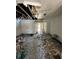 Damaged living room after a fire, showing exposed beams and debris throughout the room at 4010 Cedarlimb Ct, Tampa, FL 33614