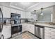 Modern kitchen with stainless steel appliances, granite countertops, and white cabinetry at 4041 Star Island Dr, Holiday, FL 34691