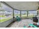 Enclosed porch featuring wood-look tile flooring and panoramic views of the neighborhood at 4041 Star Island Dr, Holiday, FL 34691