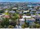 An aerial view shows the home surrounded by lush greenery in a waterfront community with a clear view of the ocean at 405 8Th N Ave, Tierra Verde, FL 33715