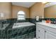 Relaxing bathroom featuring a jetted tub with tile surround and a single sink vanity at 405 8Th N Ave, Tierra Verde, FL 33715