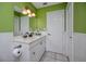 Bathroom with lime green walls, tile floors, white cabinets, a dark faucet, and decorative lighting at 405 8Th N Ave, Tierra Verde, FL 33715
