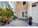 A lovely front entrance featuring a double-door entryway, a blue welcome mat, potted plants, and a two-car garage at 405 8Th N Ave, Tierra Verde, FL 33715