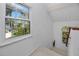Bright staircase landing with white walls and trim, natural light, and a view of lush greenery outside at 405 8Th N Ave, Tierra Verde, FL 33715