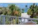 Balcony overlooking the water, palm trees, cars and the beach at 405 8Th N Ave, Tierra Verde, FL 33715