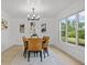 Charming dining room with elegant chandelier, stylish decor and a view of the landscaped backyard at 4210 Palm Dr, Punta Gorda, FL 33950