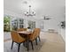 Well-lit dining room with modern chandelier, comfortable seating, view of outdoor pool and beautiful backyard at 4210 Palm Dr, Punta Gorda, FL 33950
