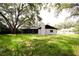 Home's backyard features a screened porch and mature tree at 4260 Saint Lawrence Dr, New Port Richey, FL 34655