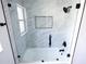 Modern bathroom featuring marble tile shower with black hardware and glass door at 4260 Saint Lawrence Dr, New Port Richey, FL 34655