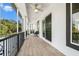A tiled balcony featuring black railings, white columns, and a decorative ceiling fan at 4353 Dewey Dr, New Port Richey, FL 34652