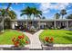 Landscaped front yard with brick pathway and flower beds leading to a charming, single-story home at 4649 Neptune Se Dr, St Petersburg, FL 33705