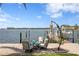 Waterfront patio with a charming seating area, providing picturesque views of the dock and tranquil water at 4649 Neptune Se Dr, St Petersburg, FL 33705