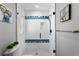 This frameless shower includes colorful accents, a rainfall shower head, and tiled walls at 4649 Neptune Se Dr, St Petersburg, FL 33705