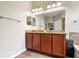 A bathroom featuring a double sink vanity with tiled floors and an oversized mirror for morning preparations at 5401 Match Point Pl, Lithia, FL 33547