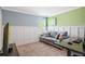 Bedroom with neutral carpet, white wainscoting, and a comfortable grey sofa at 5401 Match Point Pl, Lithia, FL 33547