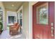 Close-up of the front door with decorative glass panel, surrounded by a covered porch at 5401 Match Point Pl, Lithia, FL 33547