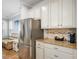 Well-lit kitchen featuring granite countertops, stainless steel refrigerator, and decorative backsplash at 5401 Match Point Pl, Lithia, FL 33547
