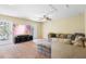 Living room with large sectional sofa, ceiling fan, recessed lights, and french doors leading to balcony at 5401 Match Point Pl, Lithia, FL 33547