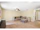Comfortable living room featuring neutral tones, a ceiling fan, and a spacious sectional sofa at 5401 Match Point Pl, Lithia, FL 33547