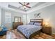 Primary bedroom with tray ceilings, hardwood floors, and ample natural light from multiple windows at 5401 Match Point Pl, Lithia, FL 33547