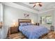 A well-lit main bedroom with a ceiling fan, wood floors, and a tray ceiling creates a comfortable retreat at 5401 Match Point Pl, Lithia, FL 33547