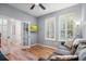 An office area with wood floors, plantation shutters, and French doors next to a comfortable gray sofa at 5401 Match Point Pl, Lithia, FL 33547