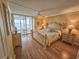 Bright bedroom featuring neutral colors, a ceiling fan, and sliding glass doors to balcony with water views at 6060 Shore S Dr # 906, Gulfport, FL 33707