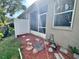A view of the backyard with a screened in patio, red mulch, stepping stones, and a privacy fence at 608 Black Lion Ne Dr, St Petersburg, FL 33716