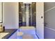 Modern bathroom featuring a sleek vanity, illuminated mirror and bathtub with black marble tile surround at 6534 Simone Shores Cir, Apollo Beach, FL 33572