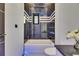 Modern bathroom featuring a sleek vanity, illuminated mirror and bathtub with black marble tile surround at 6534 Simone Shores Cir, Apollo Beach, FL 33572