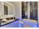 Modern bathroom featuring a sleek vanity, illuminated mirror and bathtub with black marble tile surround at 6534 Simone Shores Cir, Apollo Beach, FL 33572