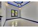 Contemporary bedroom with tiled floor, tray ceiling, and a window with a view of palm trees at 6534 Simone Shores Cir, Apollo Beach, FL 33572