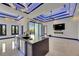 This modern kitchen showcases an island with a dark countertop and bar seating, and custom lighting at 6534 Simone Shores Cir, Apollo Beach, FL 33572