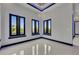 An open room with dark trim windows and light gray walls reflects light on the tile floor at 6534 Simone Shores Cir, Apollo Beach, FL 33572