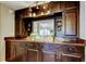 Elegant bar area features dark wood cabinetry, granite countertop, and a mirrored backsplash at 700 Starkey Rd # 1216, Largo, FL 33771