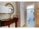 Inviting foyer with round mirror, decorative table, and access to a full bathroom provides convenient powder room at 700 Starkey Rd # 1216, Largo, FL 33771