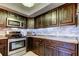 This is a detailed view of a kitchen with stainless steel appliances and backsplash, and dark wood cabinets at 700 Starkey Rd # 1216, Largo, FL 33771