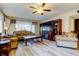 Living room featuring wood flooring, a ceiling fan, a large window, and a brown entertainment center at 700 Starkey Rd # 1216, Largo, FL 33771