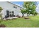 Spacious backyard featuring a patio, lush lawn, and a view of the home's exterior at 7030 Summer Holly Pl, Riverview, FL 33578