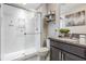 Modern bathroom featuring a glass shower, storage shelves, granite countertops, and decorative fixtures at 7030 Summer Holly Pl, Riverview, FL 33578