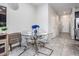 Dining area featuring a modern glass table, chairs, and access to the kitchen and hall at 7030 Summer Holly Pl, Riverview, FL 33578