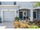 Close-up of townhome with charming covered front porch and a black front door at 7030 Summer Holly Pl, Riverview, FL 33578
