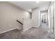Carpeted upstairs hallway featuring neutral walls and trim, a staircase and access to multiple rooms at 7030 Summer Holly Pl, Riverview, FL 33578