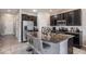 Open-concept kitchen with island seating, stainless appliances, and dark cabinets at 7030 Summer Holly Pl, Riverview, FL 33578