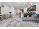 Open concept living room with modern furnishings, including a glass dining table and a plush gray sofa at 7030 Summer Holly Pl, Riverview, FL 33578