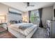 Comfortable main bedroom featuring a tufted headboard, bench, ceiling fan, and soft, natural light from a window at 7030 Summer Holly Pl, Riverview, FL 33578